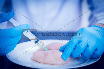 Food scientist injecting raw chicken
