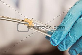 Food scientist putting raw chicken in test tube