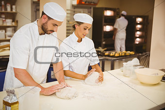 Team of bakers kneading dough