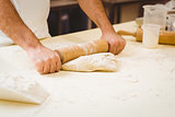 Baker rolling dough at a counter