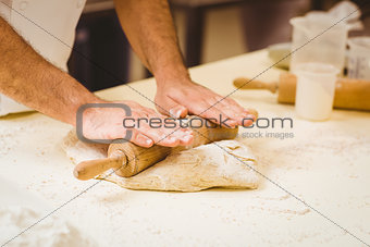 Baker rolling dough at a counter