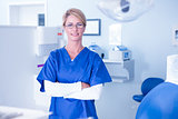 Portrait of a dentist smiling at camera with arms crossed