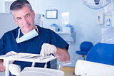 Dentist picking up tool and smiling at camera