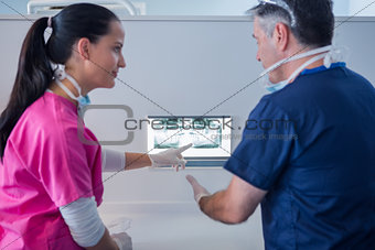 Dentist and assistant looking at x-ray together
