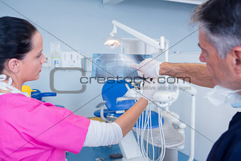 Dentist showing x-ray to his assistant