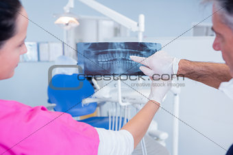 Dentist and assistant examining x-ray together