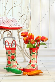 Iron chair with little rain boots and tulips 