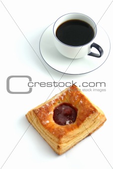 Coffee and a bun on white background
