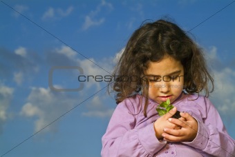 littel girl holding plant