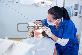 Dentist examining a patients teeth under bright light