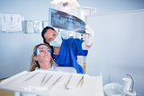 Dentist in mask explaining x-ray to patient