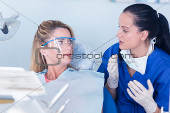 Dentist talking with patient in chair