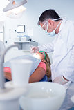 Dentist in surgical mask examining a patients teeth