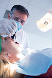 Dentist examining a patients teeth under bright light