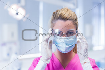 Dentist in surgical mask and protective glasses