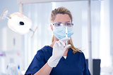 Dentist in mask and glove holding an injection