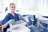 Dentist sitting with tray of tools smiling at camera