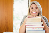Smiling blonde mature student with stack of books