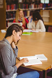 Focused student sitting at desk reading text book