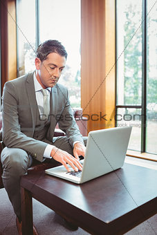 Focused handsome businessman working at laptop
