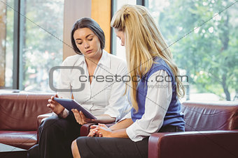 Thoughtful business team talking and using tablet