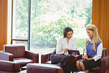 Businesswomen having a meeting and using tablet