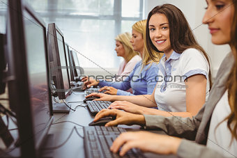 Happy woman in computer room smiling at camera