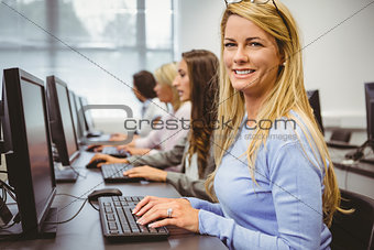 Happy woman in computer room smiling at camera