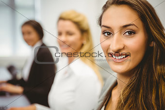 Happy women in computer room smiling at camera