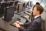 Three focused people working in computer room