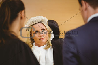 Judge and lawyer listening the criminal in handcuffs