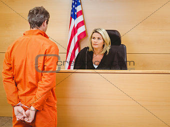 Judge and criminal speaking in front of the american flag