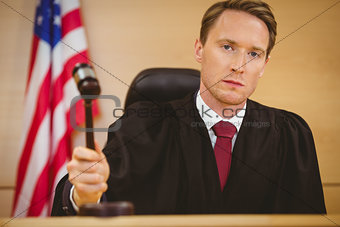 Serious judge about to bang gavel on sounding block
