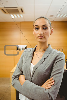 Unsmiling lawyer looking at camera crossed arms
