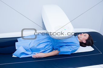 Sick woman lying on a x-ray machine