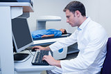 Doctor looking his computer while proceeding a radiography
