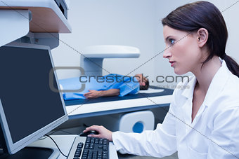 Doctor looking her computer while proceeding a radiography