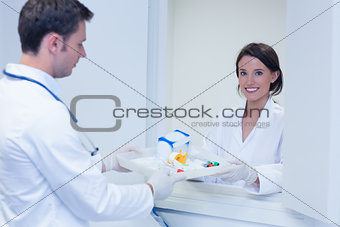 Portrait of a smiling woman taking tray with blood samples