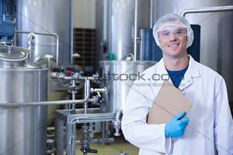 Smiling scientist looking at camera holding a clipboard