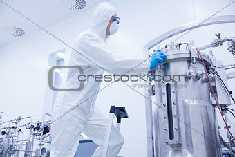 Scientist in protective suit standing on ladder