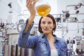 Stylish girl in denim jacket holding beaker of beer