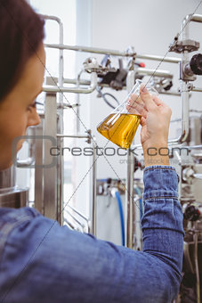 Stylish girl in denim jacket holding beaker of beer