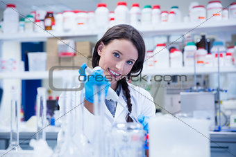 Smiling female scientist using a pipette
