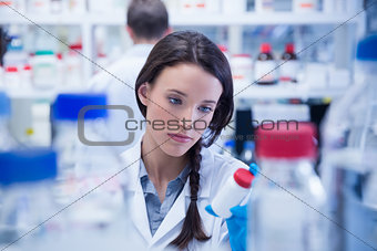 Young chemist picking up the bottles on the shelf