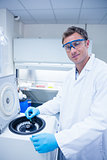 Smiling chemist using a centrifuge