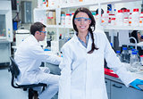 Portrait of a smiling chemist leaning against desk