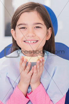 Smiling young patient holding teeth