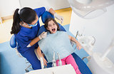 Pediatric dentist examining her patient with mouth open