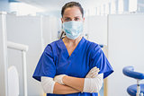 Dentist wearing surgical mask with arms folded