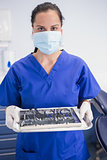 Portrait of a dentist with surgical mask and holding tray